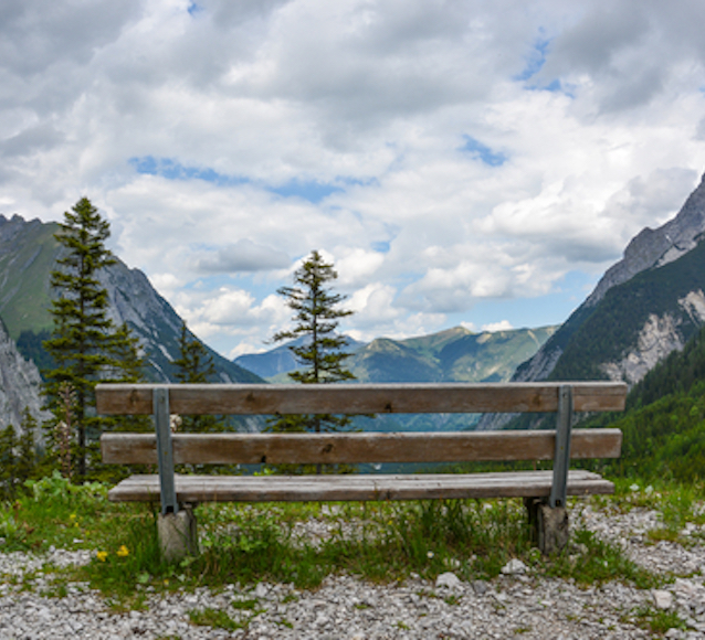 A wooden bench to rest on a hill in the mountains of the Karwendelgebirge, Austria